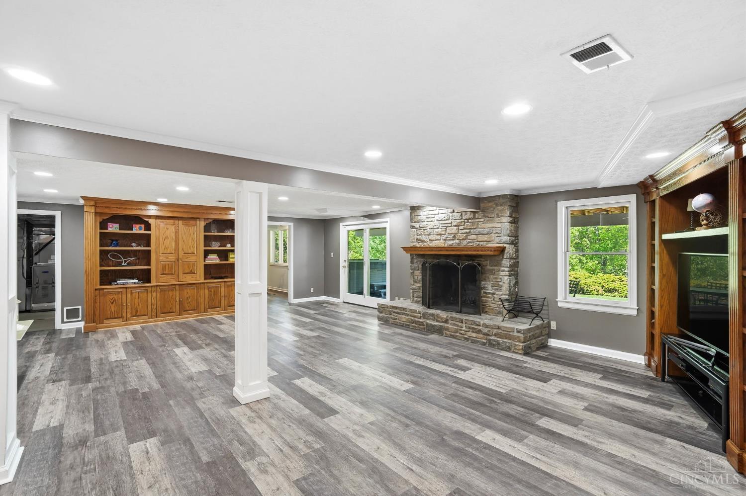 2780 Walsh Road Cincinnati, OH 45208 - Photo 41 of 68 The finished lower level offers exceptional versatility and scale, anchored by a spacious second family room with a striking stone fireplace, built-in media cabinetry, and walkout access to the outdoors—creating an ideal setting for both everyday living and entertaining. This expansive level continues with a full kitchen, dedicated game room, hobby room, exercise space, abundant storage and a convenient half bath. Thoughtfully designed to accommodate a variety of lifestyles, it functions effortlessly as an extension of the home’s living space with room to gather, relax, and play.