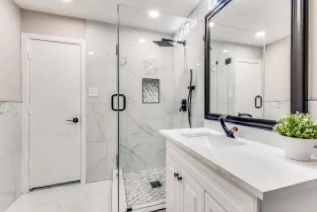 a bathroom with a shower sink and mirror