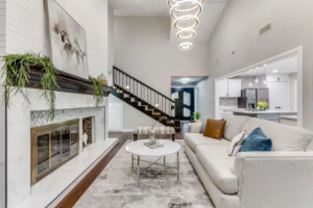 a living room with furniture a fireplace and a chandelier