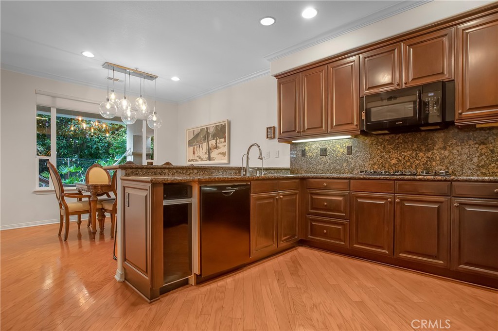 3 Avenida Cristal San Clemente, CA 92673 - Photo 13 of 36 a kitchen with stainless steel appliances granite countertop wooden cabinets a sink a stove a dining table and chairs