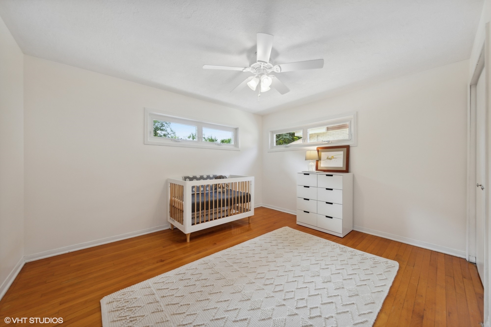 186 West Burlington Street Riverside, IL 60546 - Photo 9 of 19 a view of a bedroom with wooden floor and windows