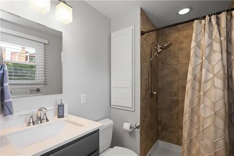 a bathroom with a granite countertop sink toilet and shower