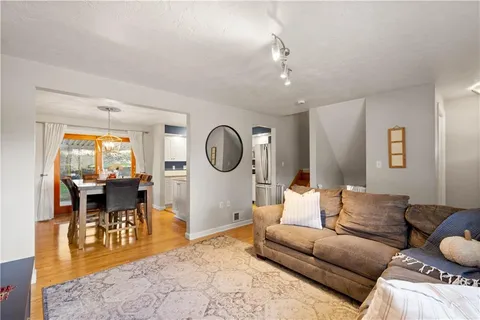 a dining room with furniture a chandelier and wooden floor
