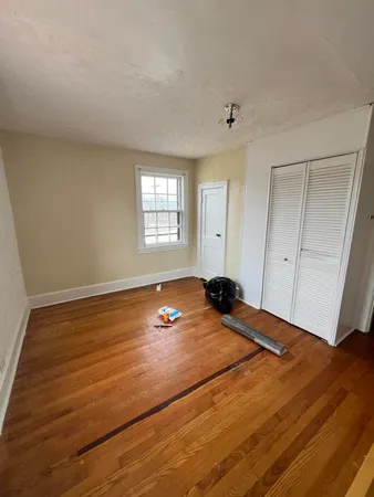 a view of a room with wooden floor and window