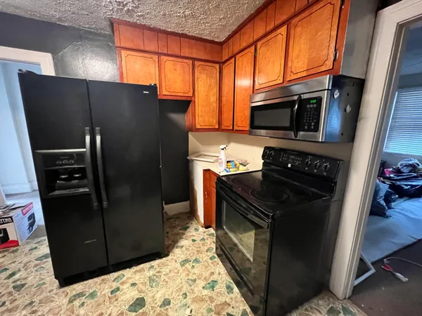 a kitchen with stainless steel appliances granite countertop a refrigerator and a stove top oven