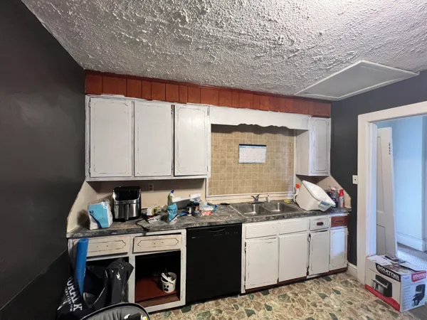 a kitchen with a stove and white cabinets