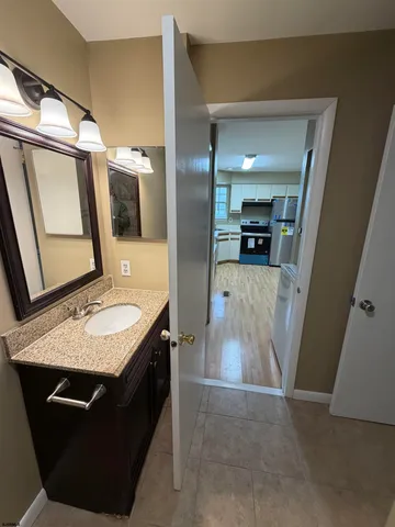 a bathroom with a granite countertop sink a vanity and mirror