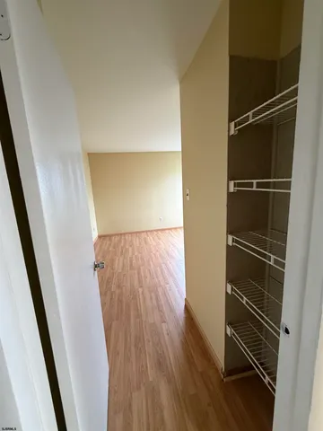 a view of walk in closet with wooden floor
