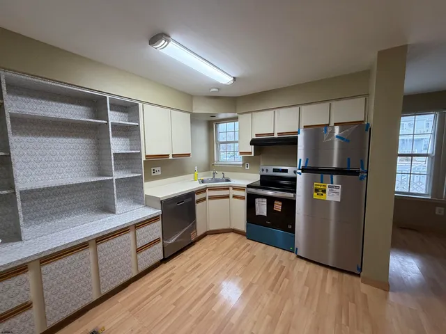 a kitchen with granite countertop a refrigerator stove and sink