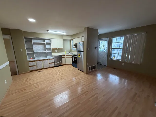 an empty room with cabinet and wooden floor