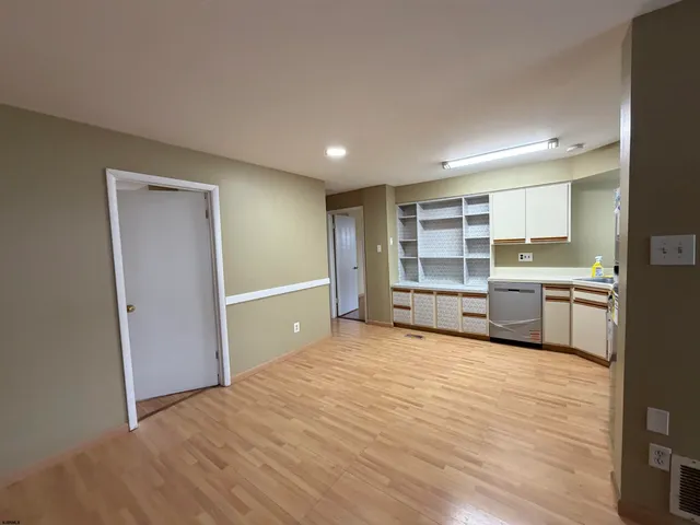 a view of a kitchen with wooden floor and windows