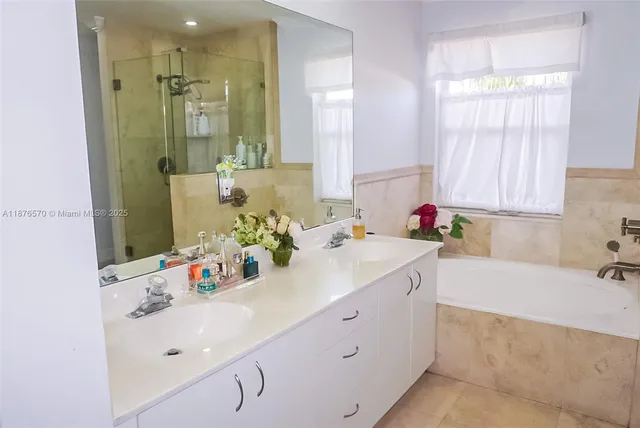 a bathroom with a tub sink and mirror