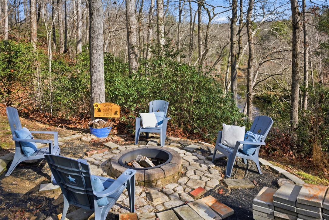 320 Holly Lane Walhalla, SC 29691 - Photo 9 of 41 This serene outdoor gathering space offers a tranquil retreat by the water's edge, perfect for quiet evenings.