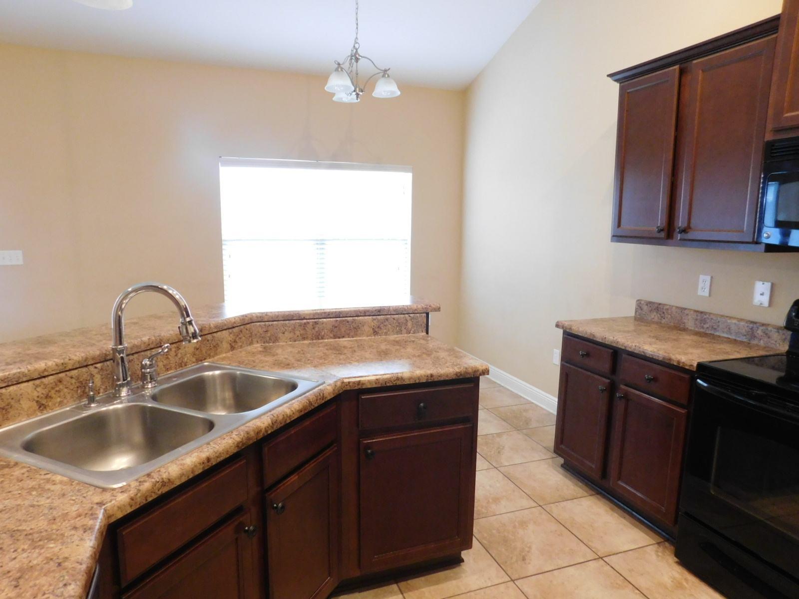 721 Lime Lane Crestview, FL 32536 - Photo 18 of 27 a kitchen with granite countertop a sink and a stove