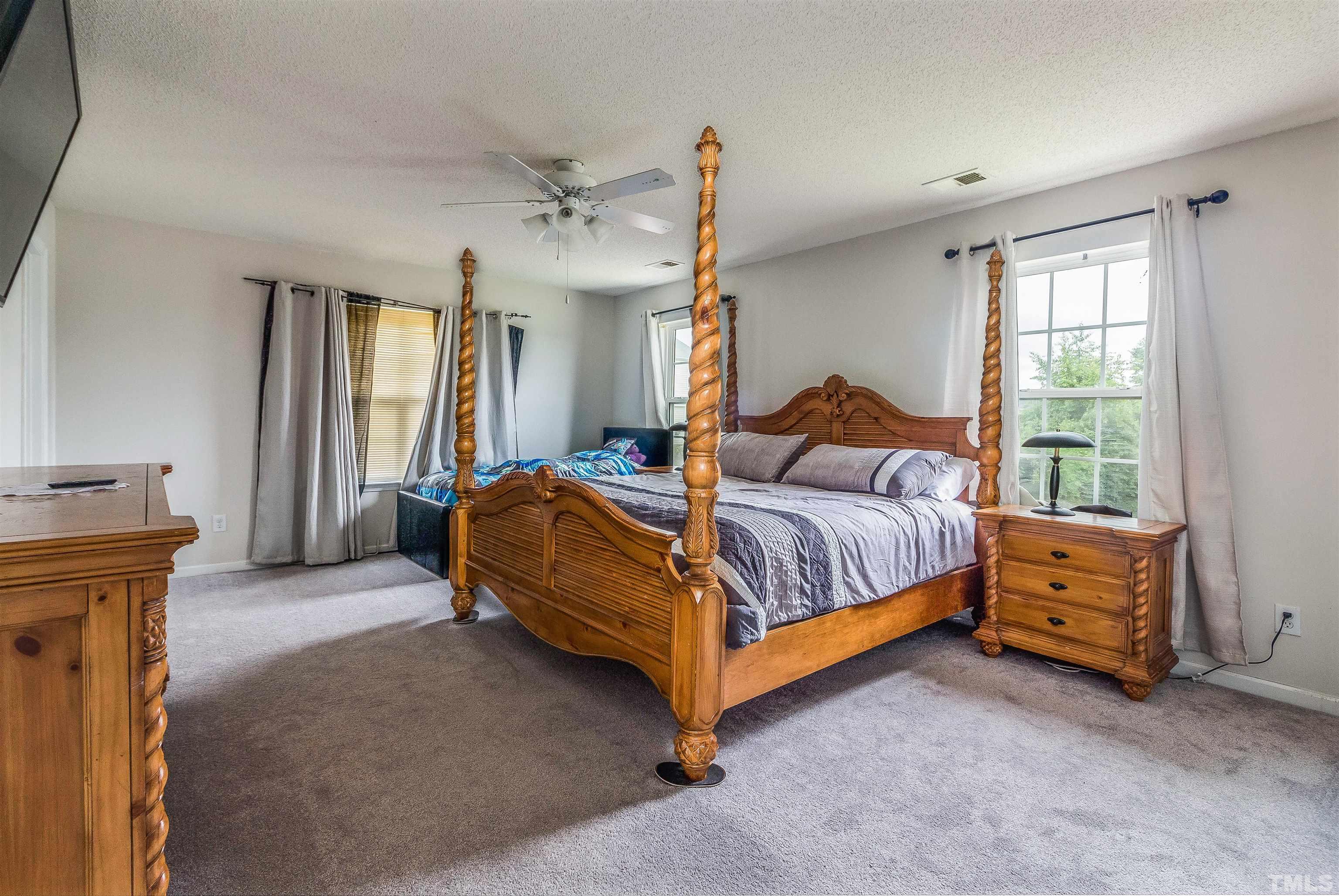 3305 Perkins Ridge Road Raleigh, NC 27610 - Photo 11 of 22 a bedroom with a bed and a chandelier