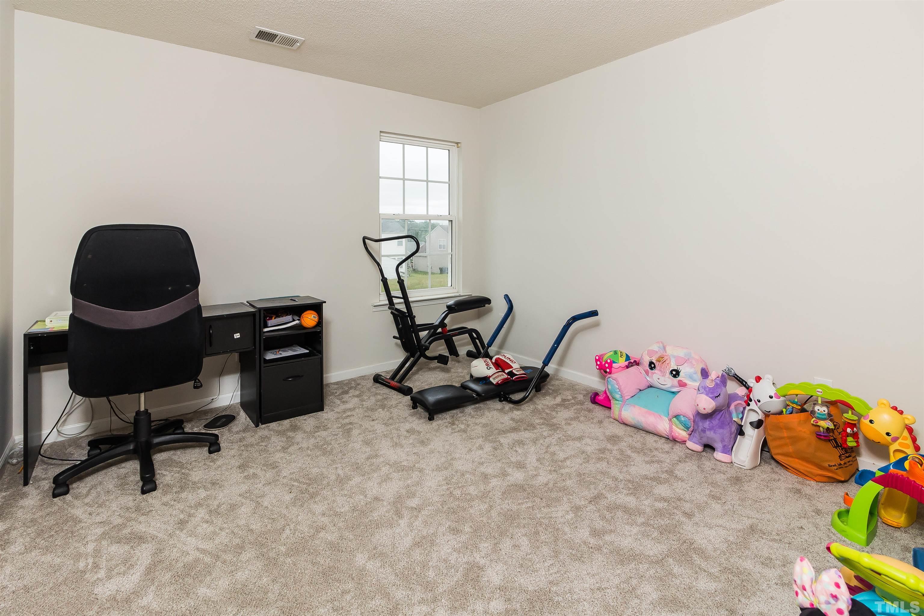 3305 Perkins Ridge Road Raleigh, NC 27610 - Photo 12 of 22 a bedroom with a bed and gym equipment