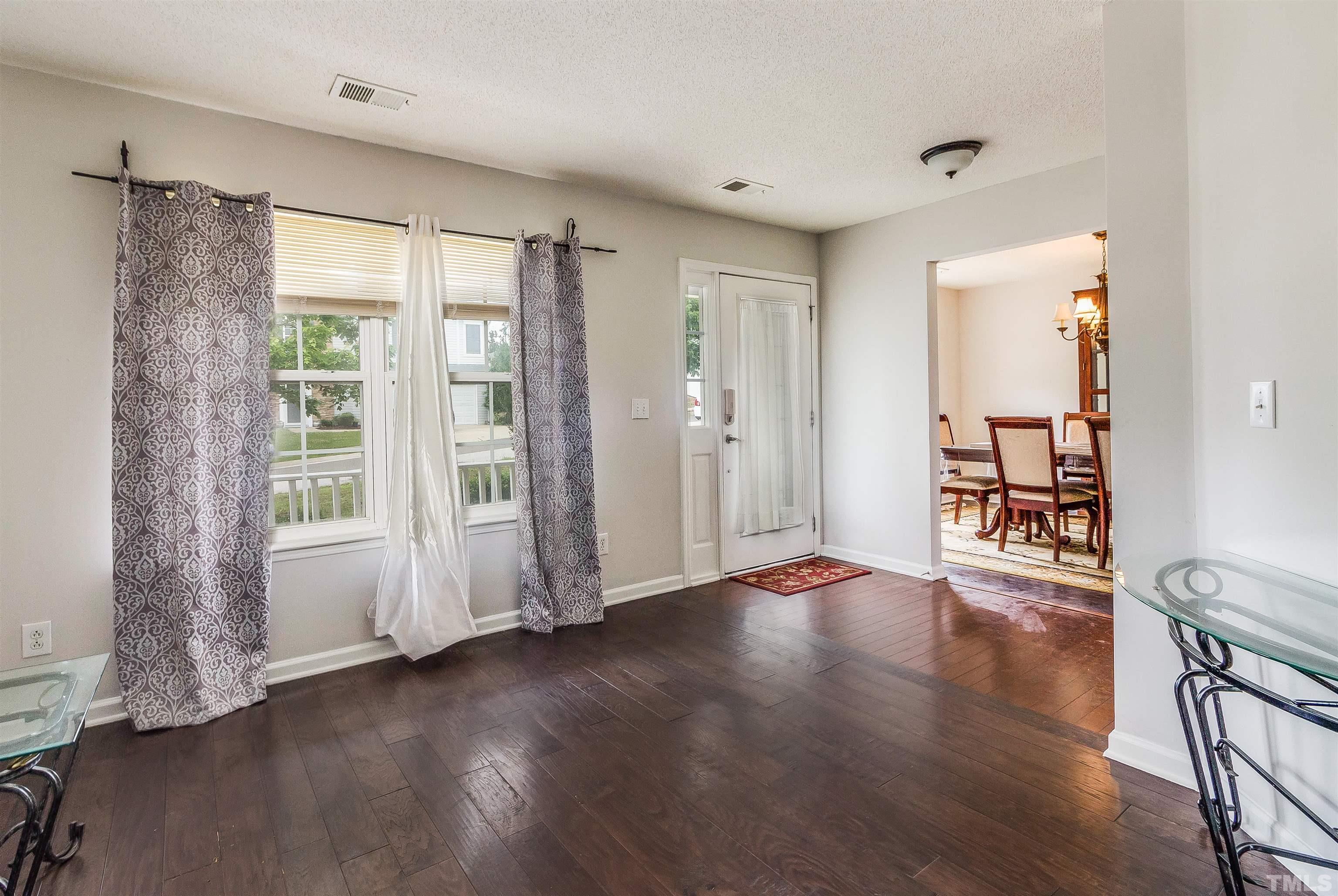 3305 Perkins Ridge Road Raleigh, NC 27610 - Photo 6 of 22 a view of an empty room with wooden floor and a window