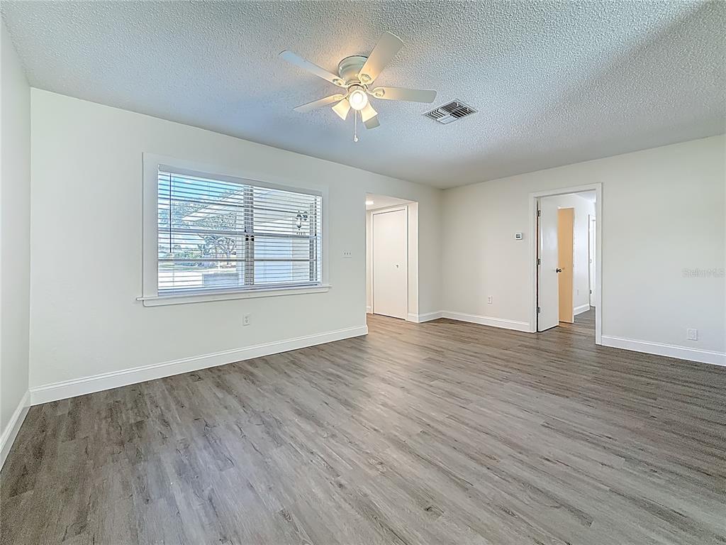 7480 118th Terrace Largo, FL 33773 - Photo 17 of 49 a view of an empty room with wooden floor and a window