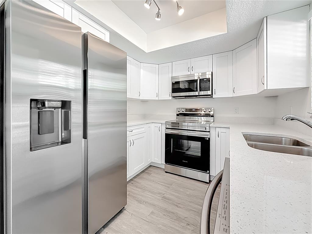 7480 118th Terrace Largo, FL 33773 - Photo 22 of 49 a kitchen with stainless steel appliances granite countertop a stove a sink and a refrigerator