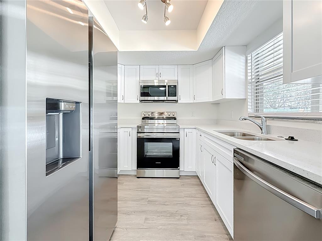 7480 118th Terrace Largo, FL 33773 - Photo 23 of 49 a kitchen with stainless steel appliances granite countertop a stove top oven a sink and dishwasher