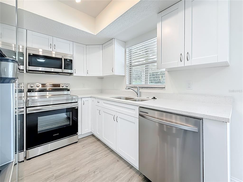 7480 118th Terrace Largo, FL 33773 - Photo 24 of 49 a kitchen with white cabinets stainless steel appliances and sink
