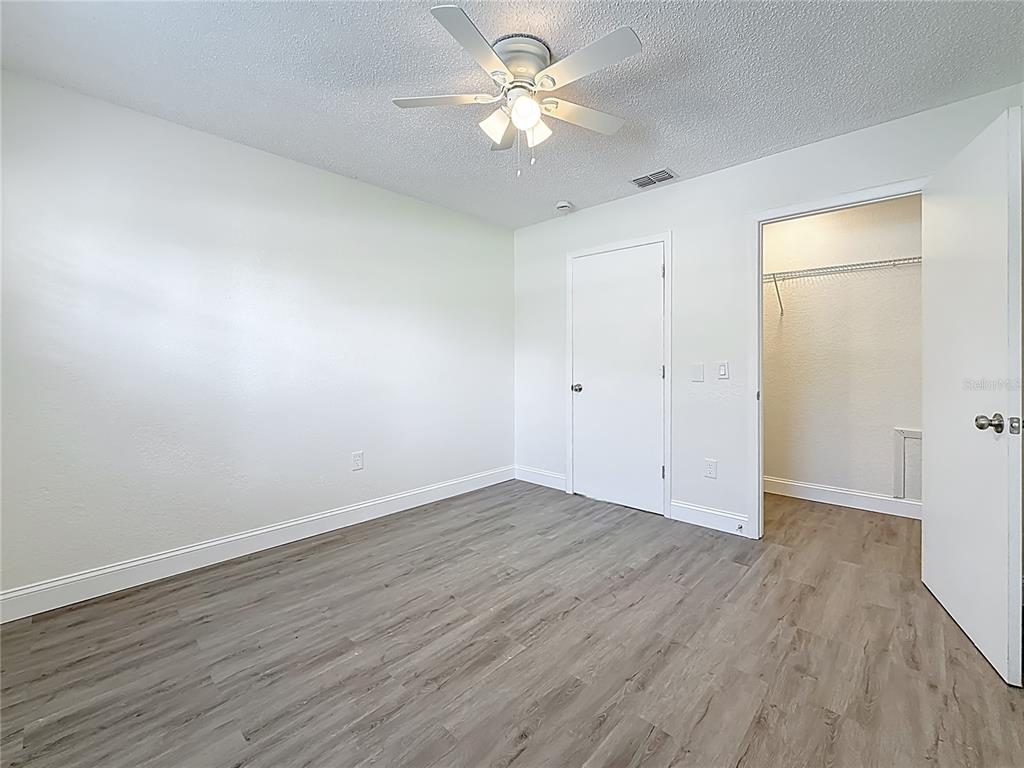 7480 118th Terrace Largo, FL 33773 - Photo 39 of 49 an empty room with wooden floor and a ceiling fan