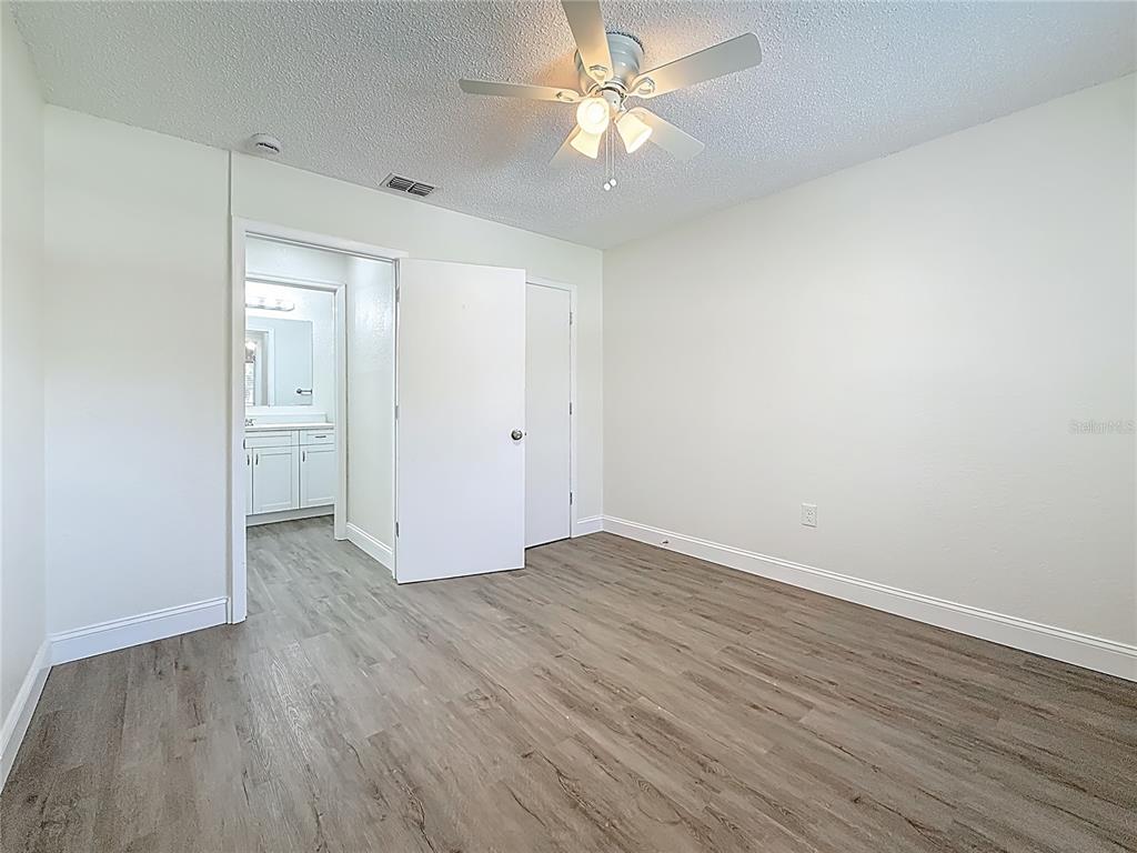 7480 118th Terrace Largo, FL 33773 - Photo 40 of 49 an empty room with wooden floor and a ceiling fan