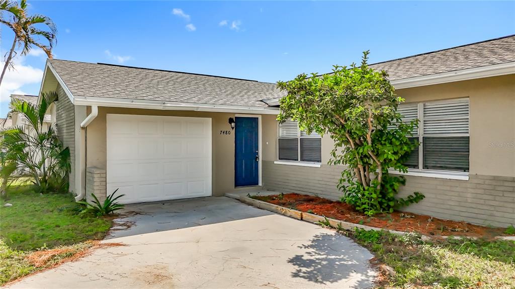 7480 118th Terrace Largo, FL 33773 - Photo 8 of 49 a front view of a house with a garden