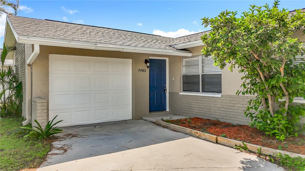 7480 118th Terrace Largo, FL 33773 - Photo 9 of 49 a front view of a house with a yard and garage