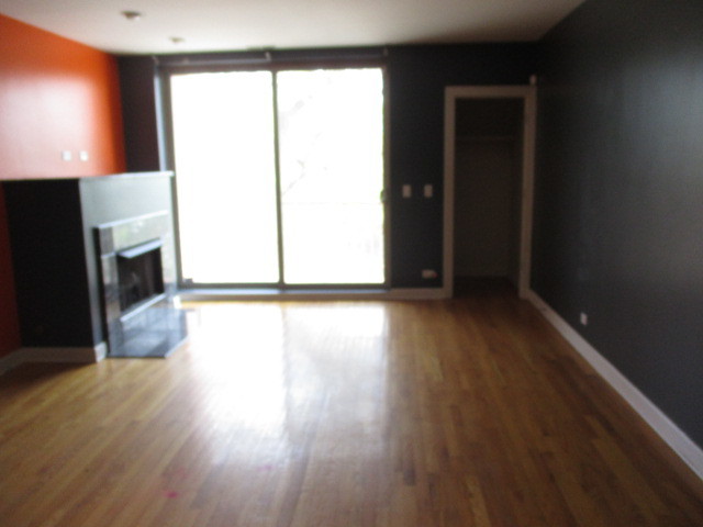 6655 South Perry Avenue, Unit 2C Chicago, IL 60621 - Photo 4 of 10 a view of a room with wooden floor and a fireplace