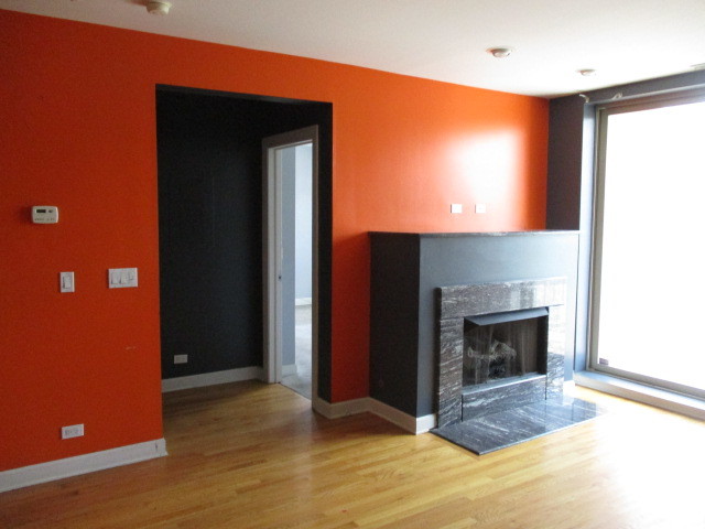 6655 South Perry Avenue, Unit 2C Chicago, IL 60621 - Photo 5 of 10 a view of an empty room with wooden floor and a fireplace
