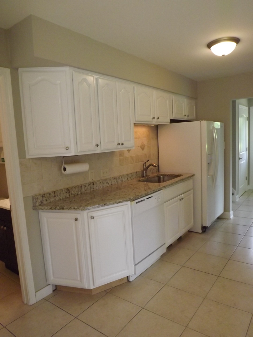 18056 Perth Avenue Homewood, IL 60430 - Photo 24 of 42 a kitchen with stainless steel appliances granite countertop a refrigerator sink and cabinets