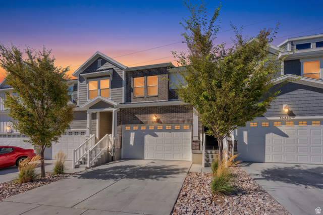 16422 Bull Spring Road, Unit 920 Riverton, UT 84065 - Photo 4 of 42 Two-story townhome with a brick and shingle facade, featuring a prominent gable roofline and an attached garage