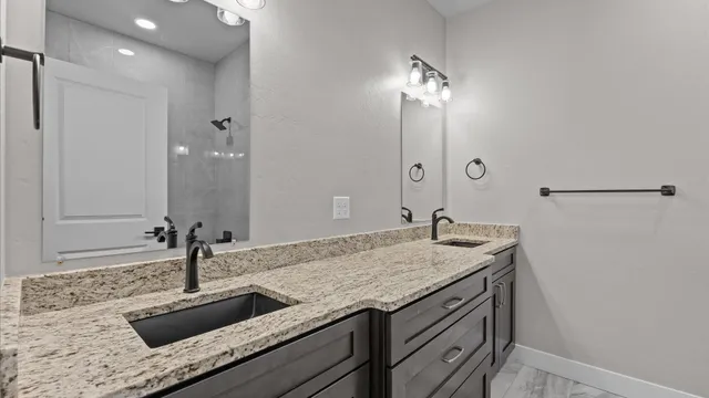 a bathroom with a granite countertop sink and a mirror