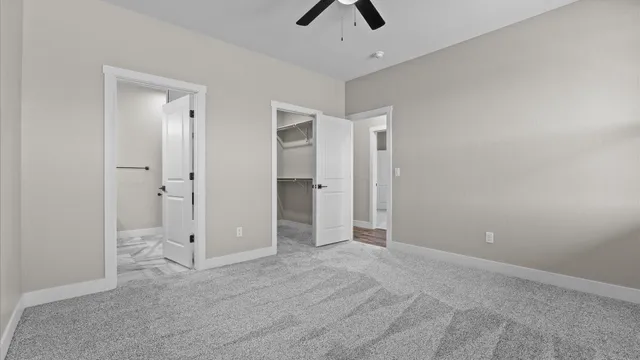 an empty room with a window and a ceiling fan