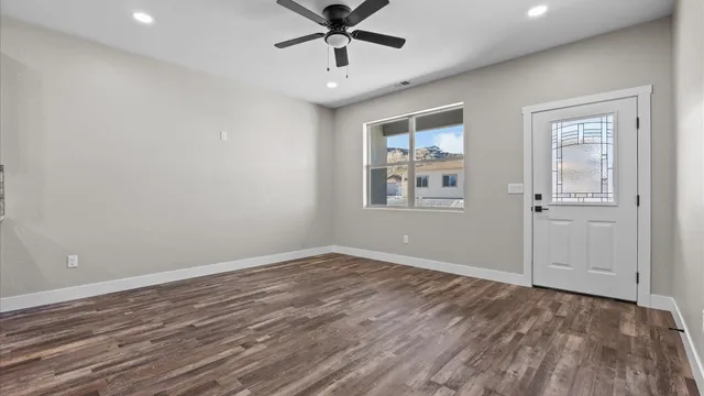 an empty room with wooden floor and windows