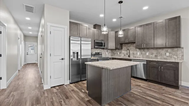 a kitchen with stainless steel appliances granite countertop a sink stove and refrigerator