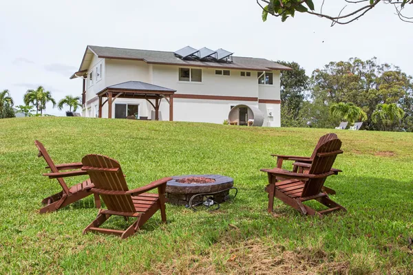 a view of a house with a yard and sitting area