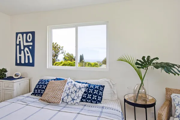 a bedroom with a large bed and a potted plant
