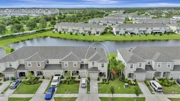 an aerial view of multiple houses with a yard