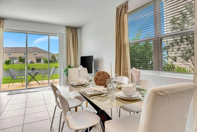 a dining room with furniture and large windows