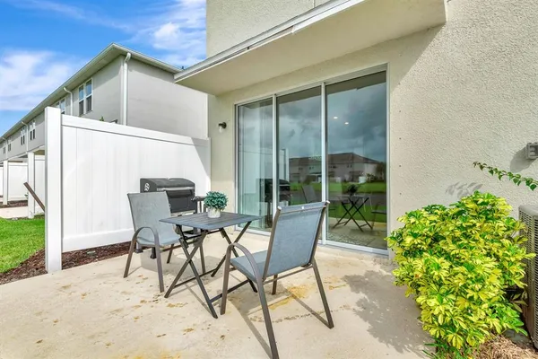 a view of a patio with table and chairs and potted plants