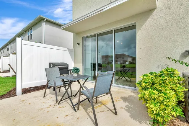 a view of a patio with table and chairs and potted plants