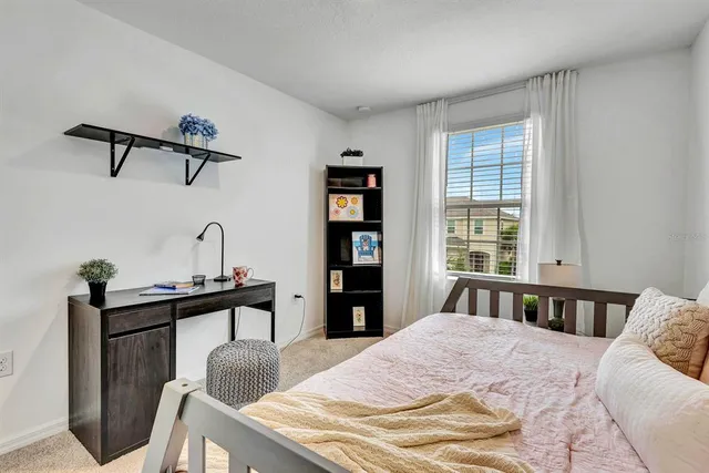 a bedroom with a bed and a lamp on dresser