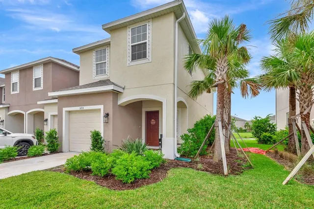 an aerial view of a house with a garden and lake view