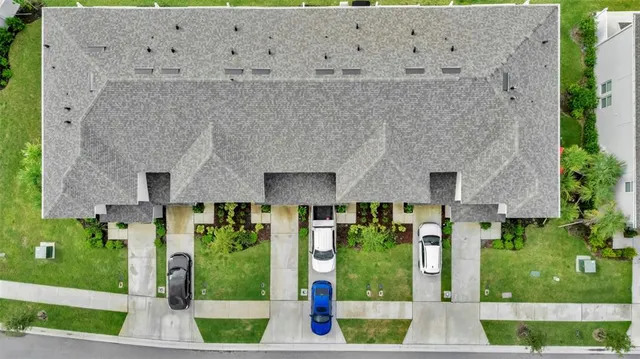 an aerial view of a city with lots of residential buildings ocean and mountain view in back