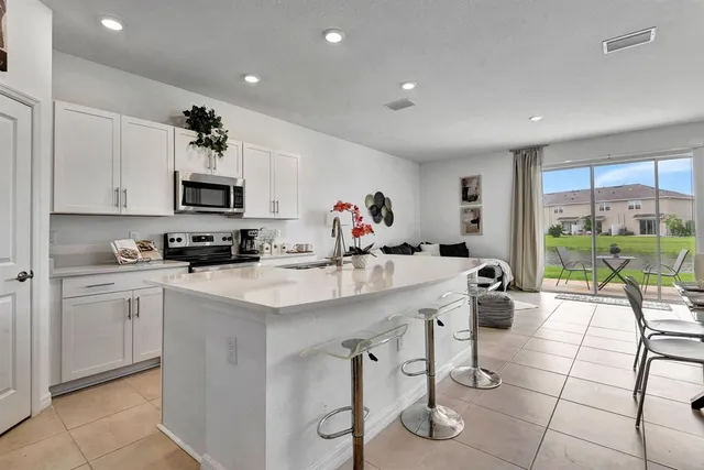 a kitchen with stainless steel appliances kitchen island granite countertop a sink and cabinets