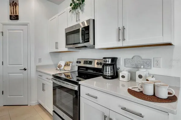a kitchen with white cabinets and appliances
