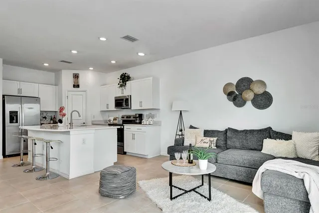 a living room with furniture and kitchen view