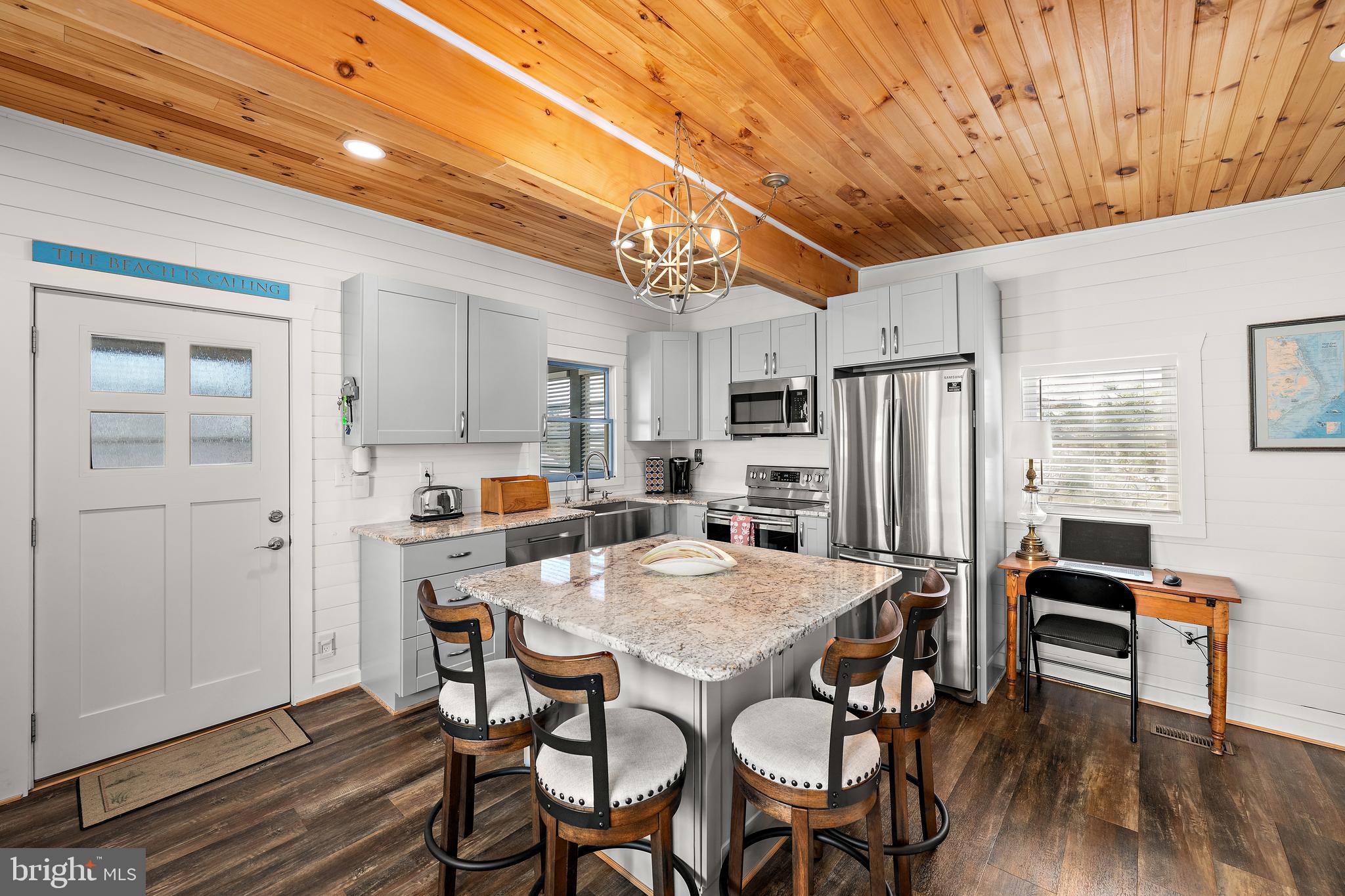 8 Virginia Avenue Milton, DE 19968 - Photo 4 of 50 a kitchen with stainless steel appliances a dining table chairs refrigerator and sink